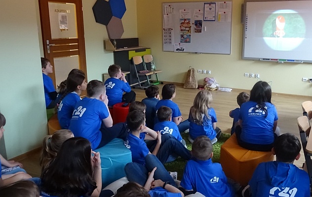 Uczniowie Niebieskiej oglądają w szkolnej świetlicy na tablicy interaktywnej film edukacyjny nt. autyzmu.